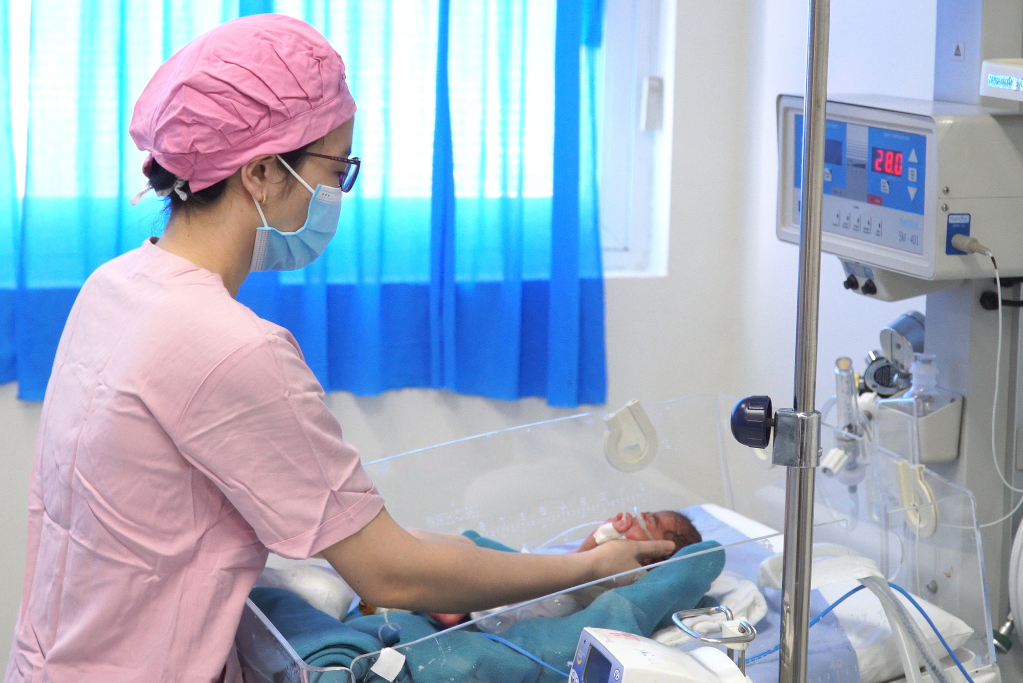 Kỳ diệu bé gái sinh non 850g, sau 5 tuần nuôi dưỡng cân nặng 1,7kg- Ảnh 1. Bé gái sinh non được nhân viên bệnh viện chăm sóc - Ảnh: BÙI HUÂN