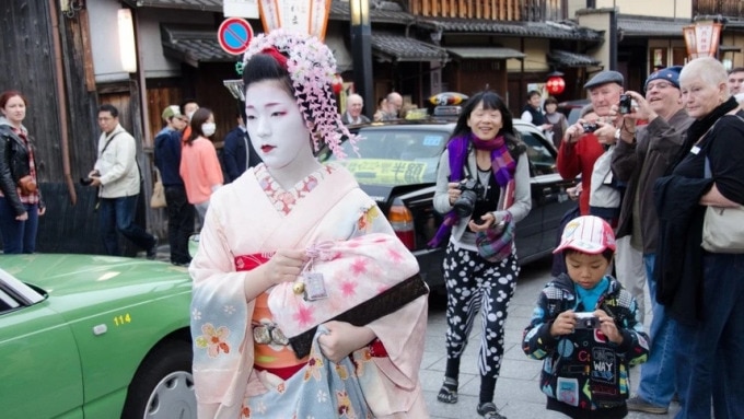 Du khách chụp ảnh maiko trên đường phố ở Kyoto. Ảnh: Shutterstock
