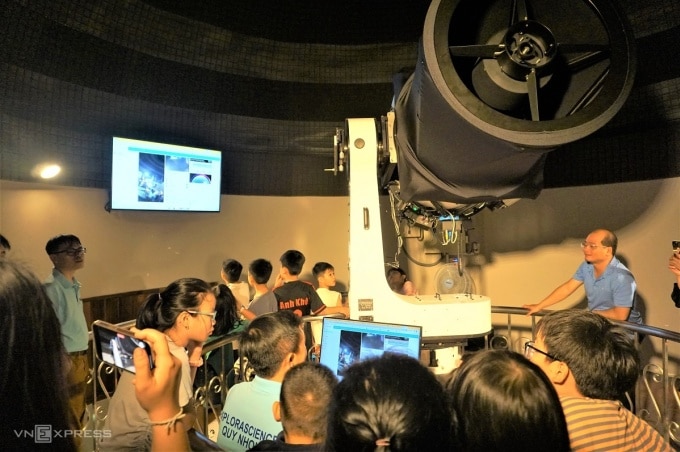 Các du khách xem hình ảnh thiên hà được ghi lại bởi kính thiên văn quang học. Ảnh: Thảo Chi