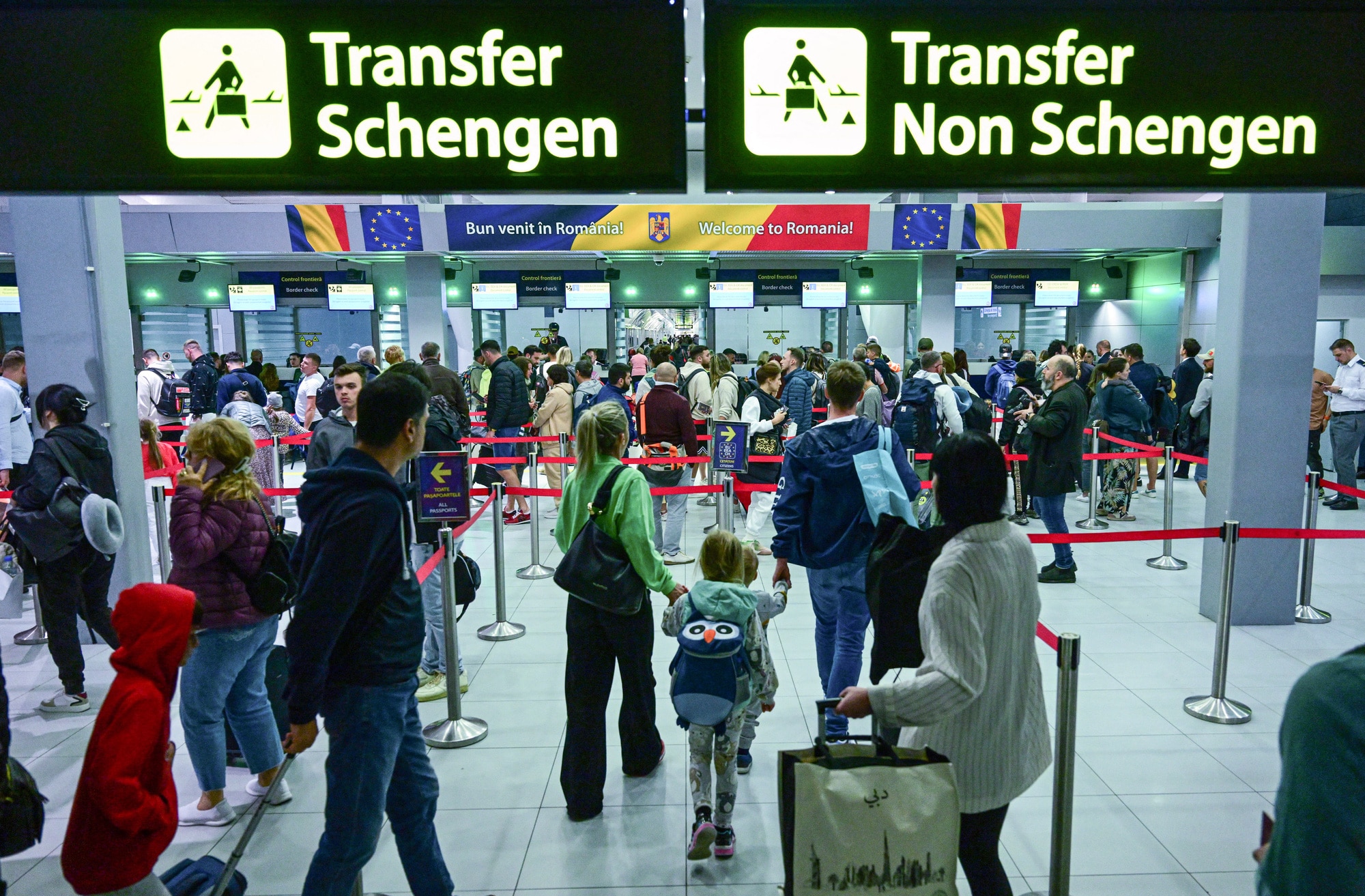 Du khách làm thủ tục tại sân bay có biển chỉ dẫn mới lắp đặt dành cho khu vực Schengen và không thuộc Schengen tại sân bay quốc tế Henri Coanda ở Otopeni, Bulgaria, ngày 31-3 - Ảnh: AFP