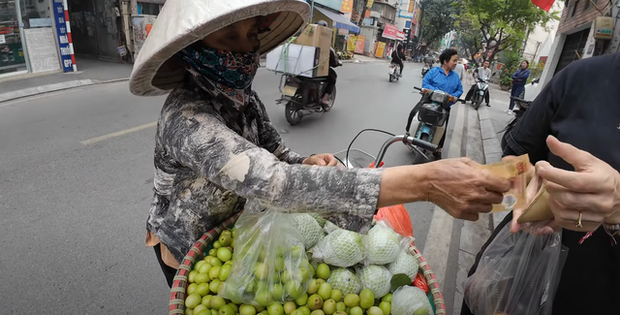 Xác minh vụ người bán hàng rong ở Hà Nội tính bán túi táo nhỏ giá 200.000 đồng cho khách Tây- Ảnh 1. Hình ảnh người phụ nữ lấy tờ 200.000 đồng từ tay du khách nước ngoài cho một túi táo ít ỏi - Ảnh cắt từ clip