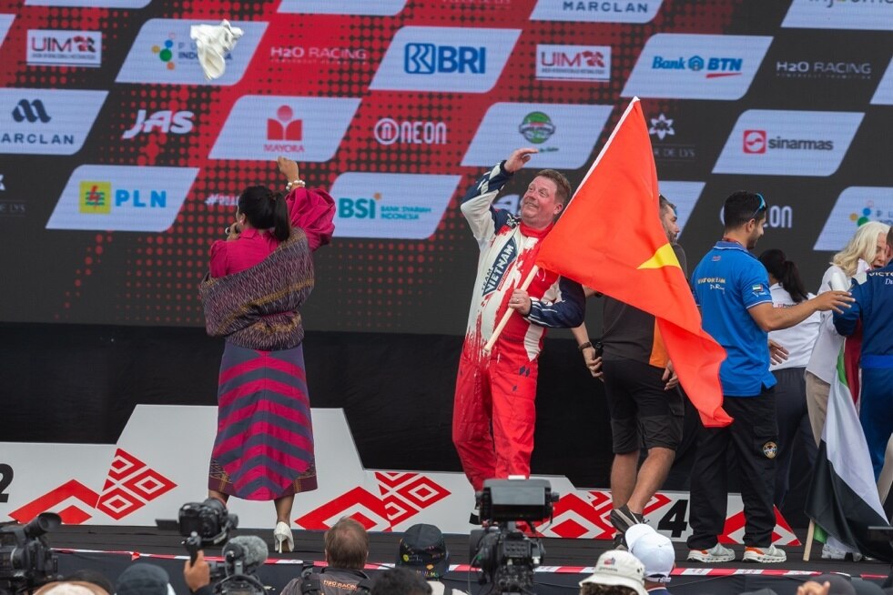 Jonas Andersson cầm cờ Việt Nam lên bục nhận giải thưởng khi phần thi cá nhân của anh về vị trí thứ 3.