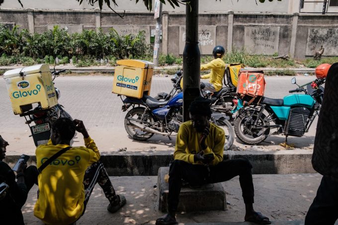 Các nhân viên giao hàng của ứng dụng Glovo nghỉ ngơi dưới gốc cây ở thành phố Lagos của Nigeria. Ảnh: R.O.W