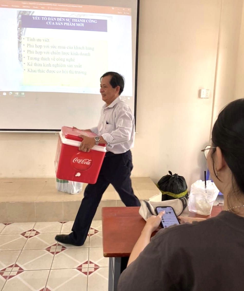 Thầy Lê Quang Thông mang thùng đựng nước đá từ nhà vào lớp học để phát tặng nước uống cho sinh viên - Ảnh: Cộng Đồng Sinh Viên Đại Học Nông Lâm TP.HCM