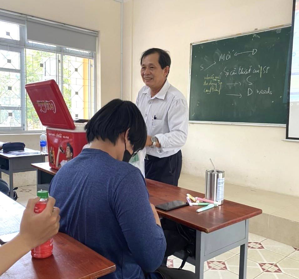 Thầy Lê Quang Thông trực tiếp phát nước cho sinh viên trên lớp học - Ảnh: Cộng Đồng Sinh Viên Đại Học Nông Lâm TP.HCM
