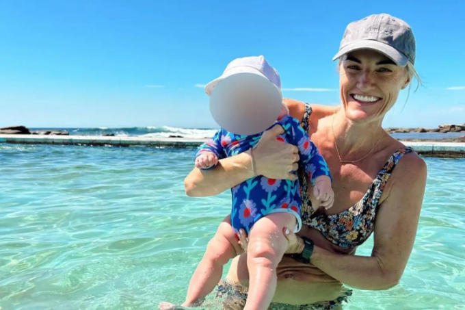 Ashlee Good ôm con tại một bãi biển ở Australia. Ảnh: SMH