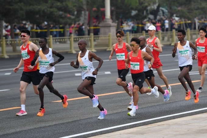 He Jie cùng các chân chạy châu Phi mặc áo trắng của Xtep trên đường chạy giải half marathon Bắc Kinh ngày 14/4. Ảnh: Xinhua
