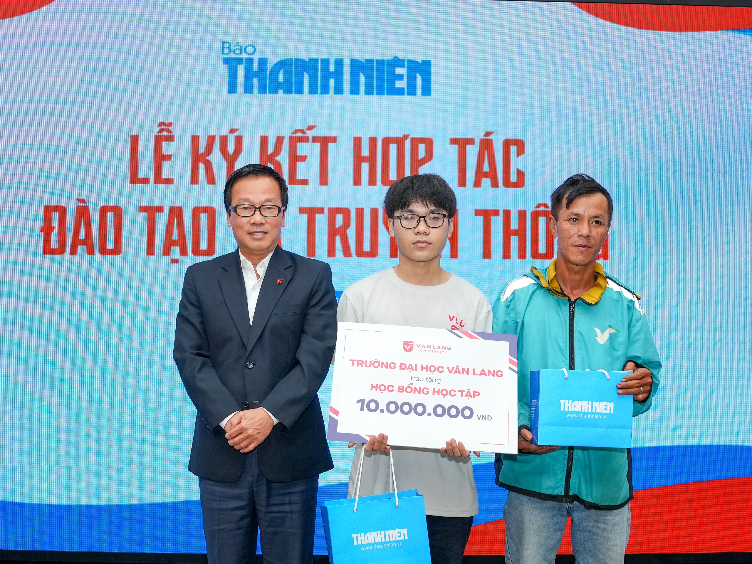 Hợp tác giữa Báo Thanh Niên và các cơ sở giáo dục: Đồng kiến tạo, cùng trách nhiệm- Ảnh 3. Tiến sĩ Võ Văn Tuấn, Phó hiệu trưởng Trường ĐH Văn Lang (bìa trái), trao học bổng cho sinh viên Huỳnh Tấn Tài