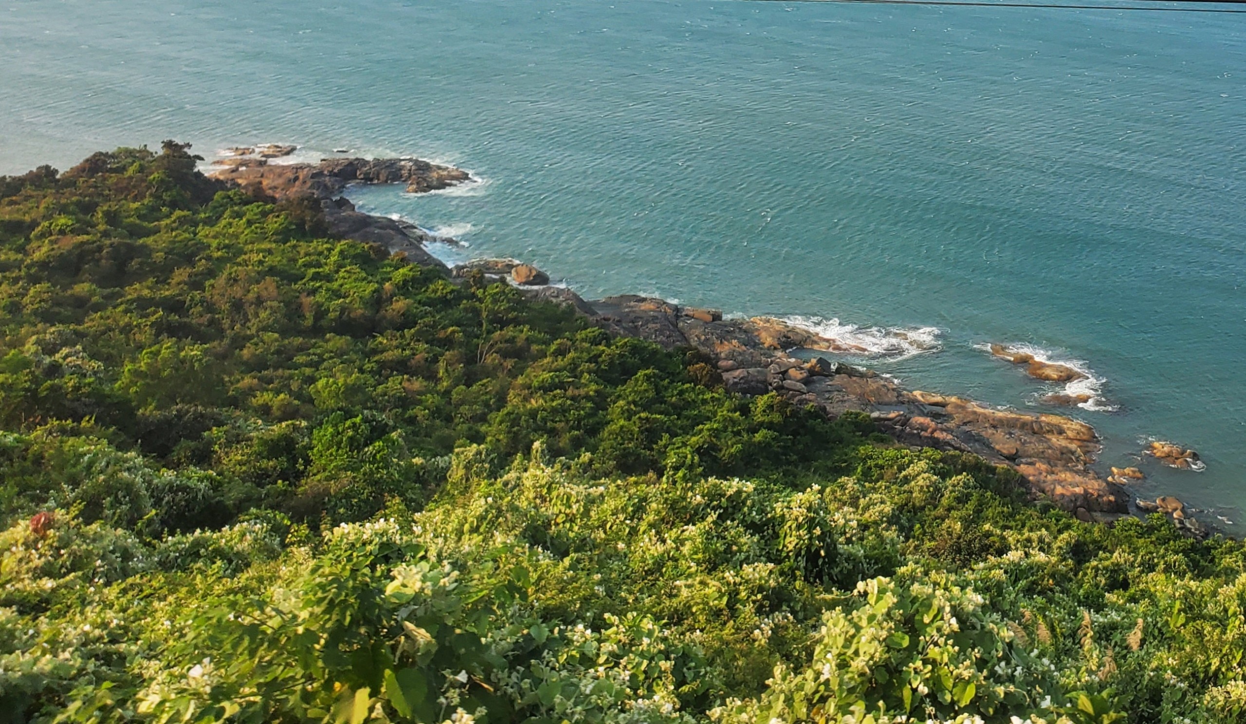 Từ cửa sổ tàu, du khách có thể ngắm những bãi đá nguyên sơ tuyệt đẹp bên bờ biển đèo Hải Vân
