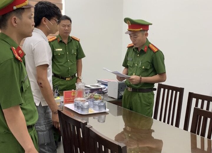 Lực lượng chức năng đọc quyết định khởi tố Nguyễn Đăng Hoài Chung. (Ảnh: C.A)