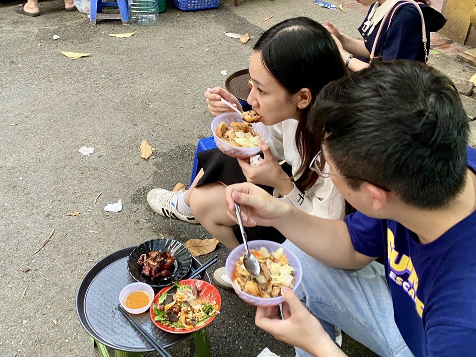 Thực khách thưởng thức những chiếc bánh nóng giòn, vừa thổi vừa ăn.