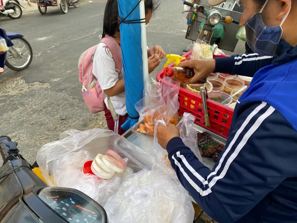 Hàng rong nhan nhản trước cổng trường ở TP.HCM, không chỉ học sinh mà phụ huynh cũng mua- Ảnh 5. Bánh tráng trộn, bánh tráng cuốn đồng giá 5.000 đồng/bịch là món ăn quen thuộc của nhiều học sinh tại các trường học ở quận Bình Tân - Ảnh: VŨ HIÊN