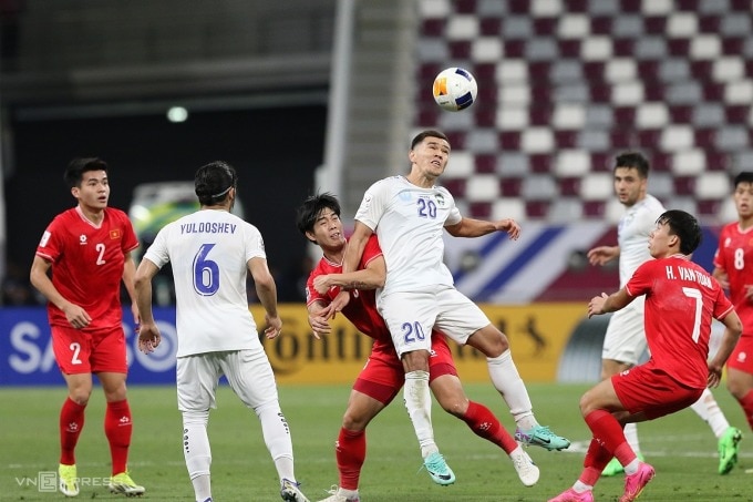 Cầu thủ Việt Nam tranh chấp bóng bổng cùng Jiyanov (số 20) - người nâng tỷ số lên 2-0 cho Uzbekistan. Ảnh: Đoàn Huynh
