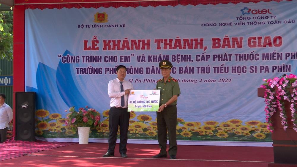 Thiếu tướng Phạm Tiến Cương - Phó Tư lệnh Bộ Tư lệnh Cảnh vệ trao các phần quà cho đại diện nhà trường.