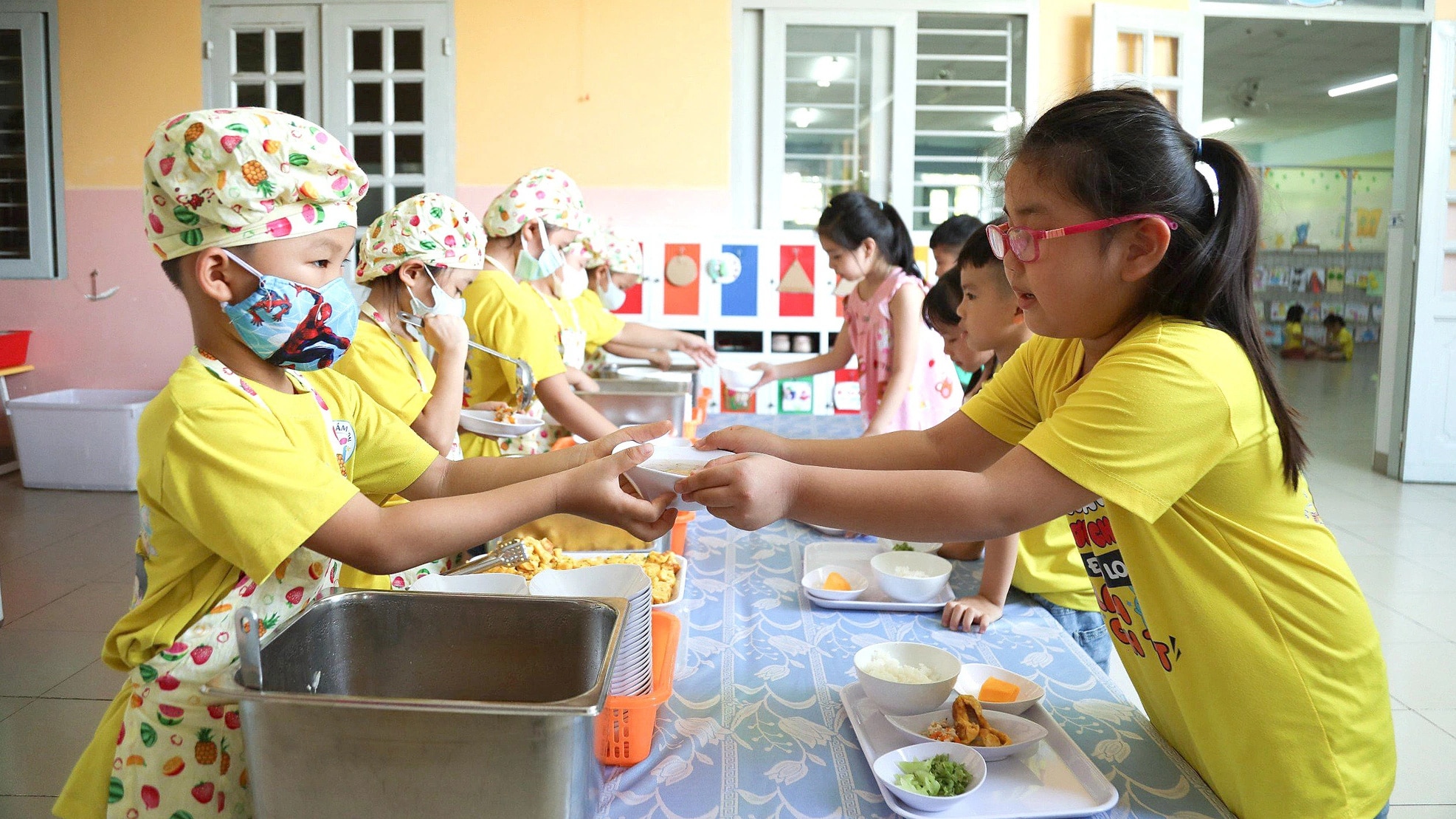 Schüler der 4. Klasse im Kindergarten Son Ca 3, Bezirk Hiep Binh Chanh, Stadt Thu Duc (HCMC) tragen Schürzen, schaufeln Reis und Suppe für ihre Freunde – Foto: PHUONG QUANYEN