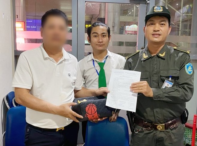 Mải nói chuyện, hành khách bỏ quên 318 triệu đồng trên xe đẩy sân bay Đà Nẵng- Ảnh 2. Lực lượng an ninh hàng không và ông Nguyễn Đăng Luyến (nhân viên điều hành taxi Mai Linh - giữa) trả lại túi xách có 318 triệu đồng cho ông L.D.T