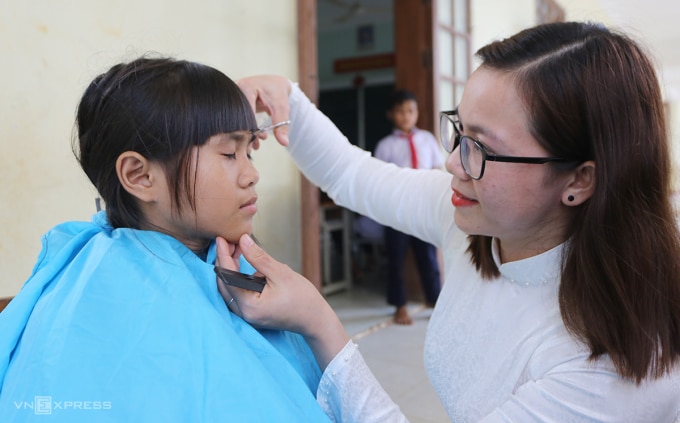 Cô Nguyễn Thị Thu Ba cắt tóc cho một học sinh nữ. Ảnh: Đắc Thành