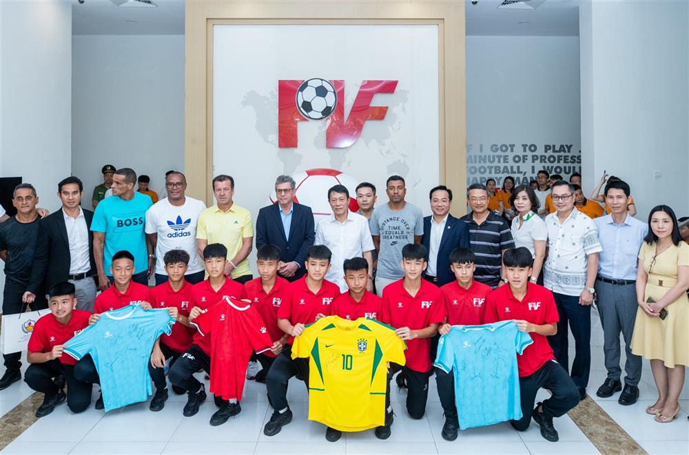 Thứ trưởng Lương Tam Quang và Đại sứ Marco Farani cùng các cựu danh thủ Brazil chụp ảnh lưu niệm tại Trung tâm đào tạo bóng đá trẻ PVF, Bộ Công an.