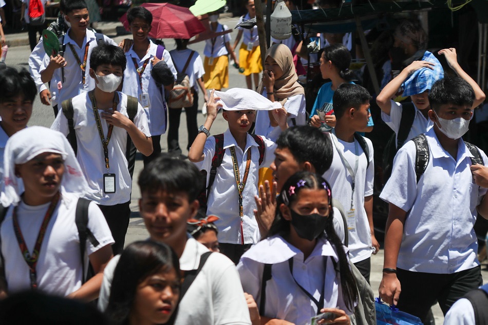Các học sinh cố gắng che chắn khỏi ánh nắng gay gắt tại Trường trung học President Corazon Aquino, thủ đô Manila - Ảnh: ABS-CBN