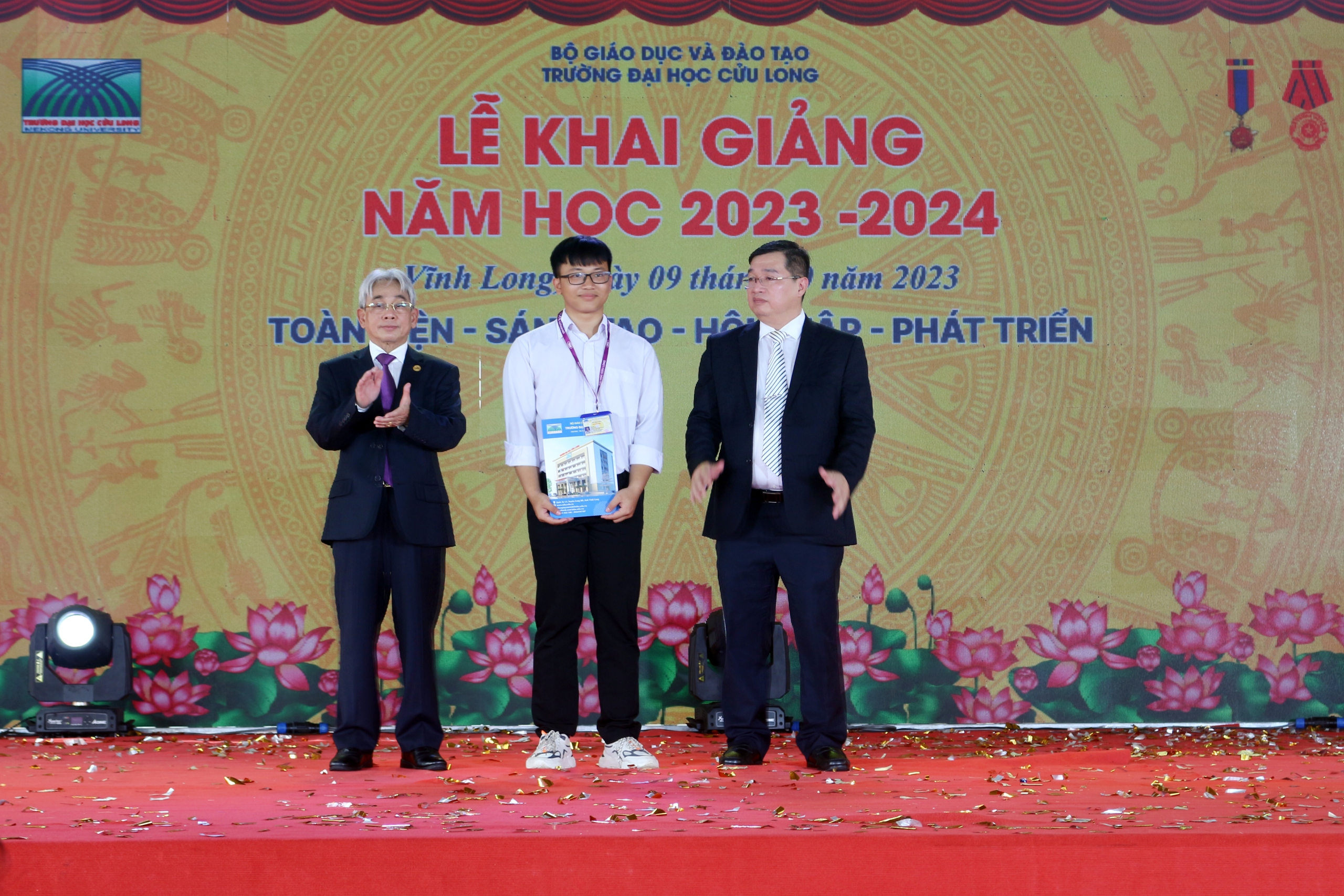 Trường ĐH Cửu Long: Nhiều chế độ chính sách dành cho tân sinh viên- Ảnh 2. Nhà giáo ưu tú, PGS-TS Lương Minh Cừ, Bí thư Đảng ủy, Hiệu trưởng Trường ĐH Cửu Long CL (trái) và ThS Lê Tôn Đức Hòa, Chủ tịch Hội đồng trường, trao quyết định cấp học bổng toàn phần cho tân SV có hoàn cảnh đặc biệt khó khăn