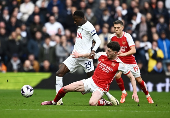 Tiền vệ Tottenham Pape Matar Sarr đi bóng qua cầu thủ Arsenal Declan Rice trong hiệp hai trận đấu trên sân Tottenham Hotspur ngày 28/4. Ảnh: Reuters