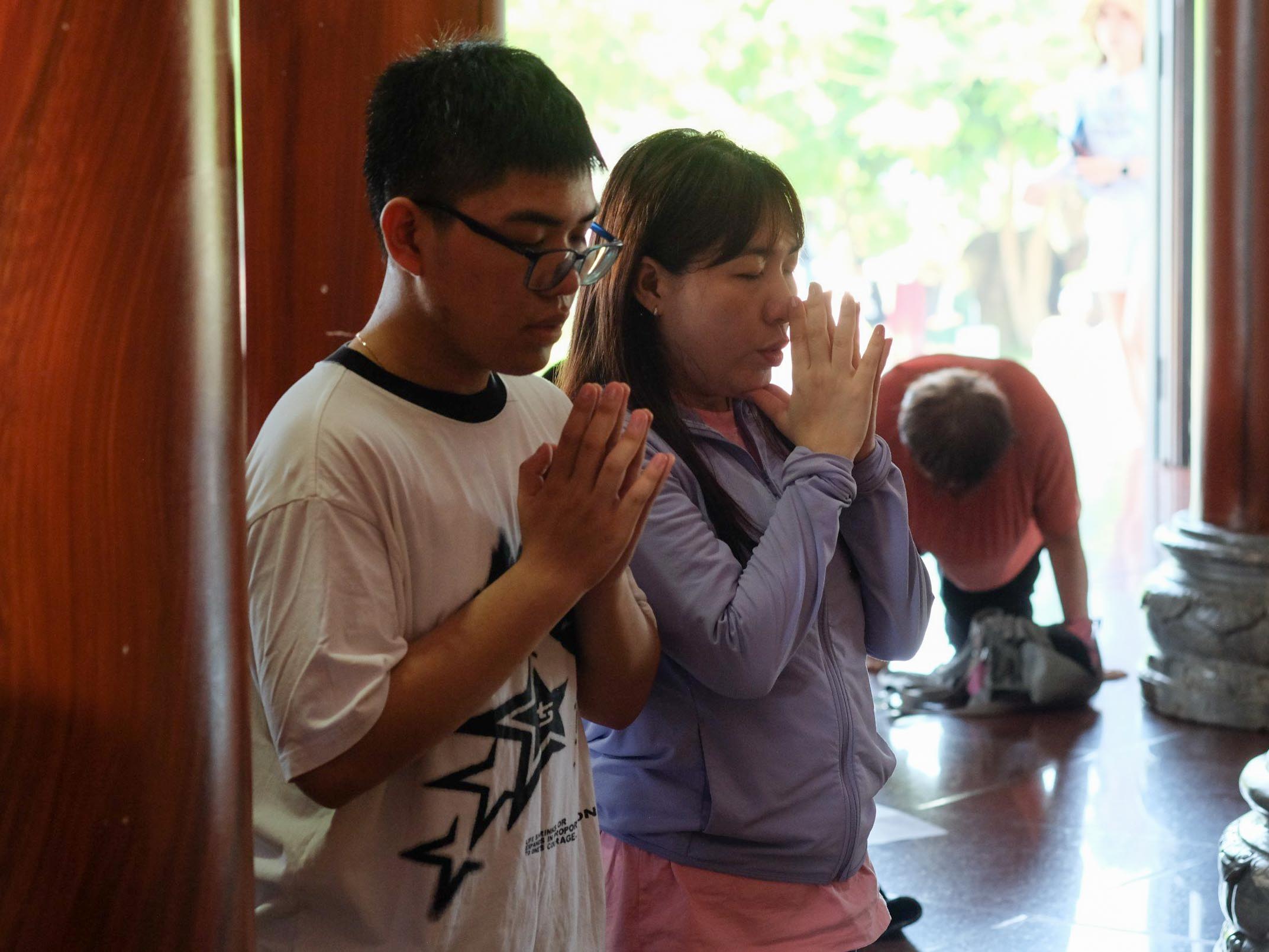 Du khách cầu nguyện tại chánh điện của Chùa Linh Ứng. Theo quy định của chùa, nếu du khách mặc quần đùi, quần lửng thì phải choàng khăn để đảm bảo sự tôn nghiêm khi vào trong chánh điện