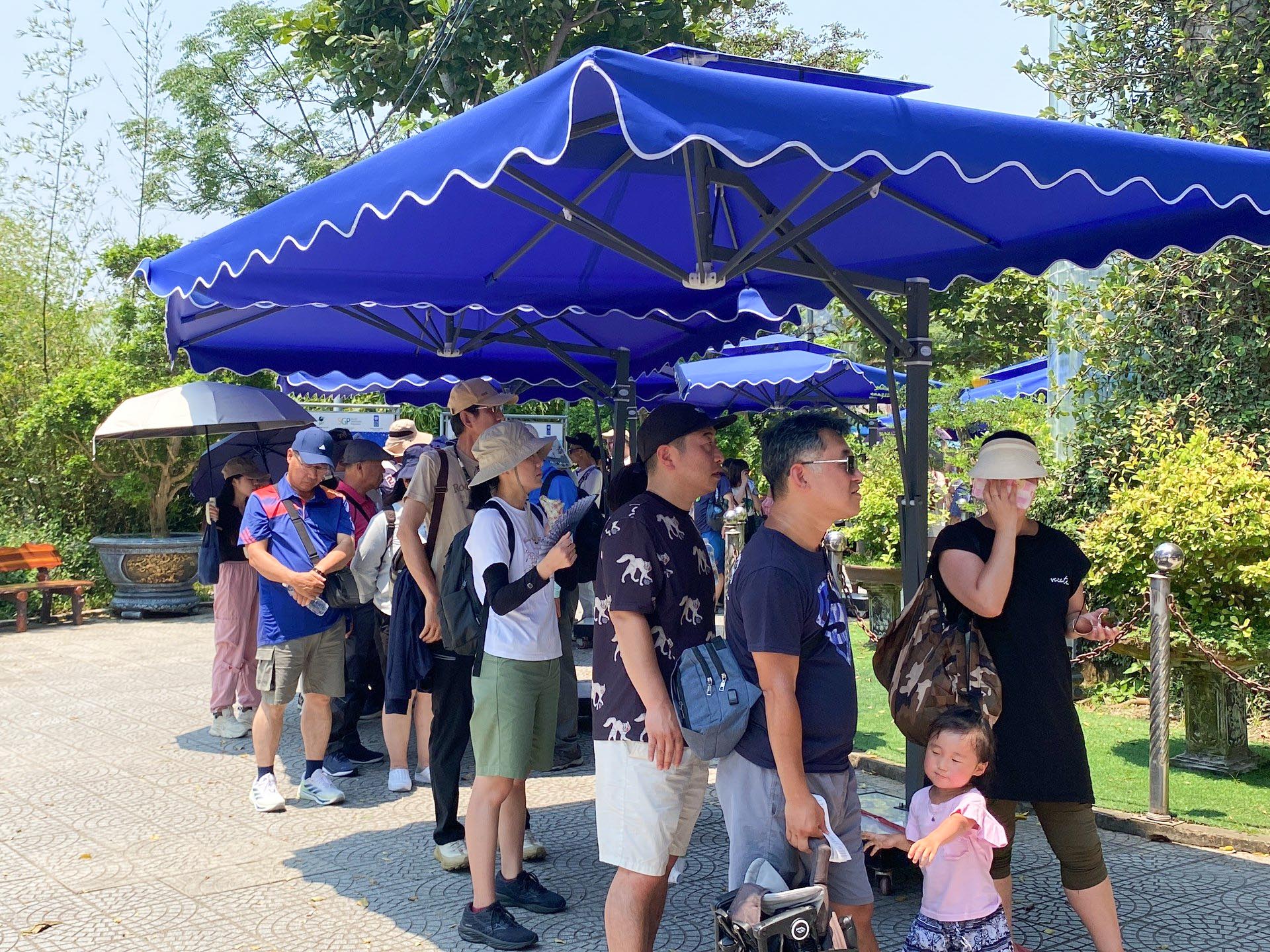 Du khách xếp hàng lên núi Sơn Trà trốn nóng hơn 40 độ C- Ảnh 6. Có rất đông du khách đội nắng xếp hàng dài chờ đi thang máy lên núi Ngũ Hành Sơn