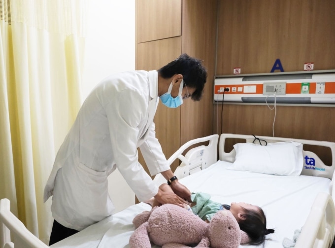 Bác sĩ Vũ kiểm tra cho bé Thanh trước xuất viện. Ảnh: Tuệ Diễm
