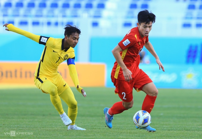 Malaysia (áo vàng) thua Việt Nam (áo đỏ) 0-2 tại lượt cuối vòng bảng U23 châu Á 2022. Ảnh: Hiếu Lương