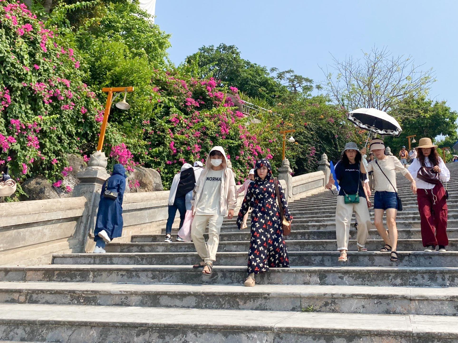 Du khách xếp hàng lên núi Sơn Trà trốn nóng hơn 40 độ C- Ảnh 1. Du khách đội nắng viếng chùa Linh Ứng trong ngày nghỉ lễ 30.4