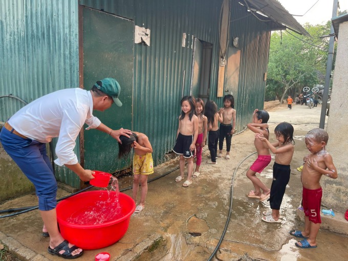 Một thầy giáo tại trường PTDTBT TH và THCS Tân Lập, xã Háng Lìa, huyện Điện Biên Đông, đang tắm cho học sinh giữa giờ ra chơi, chiều 22/4. Ảnh: Nhà trường cung cấp