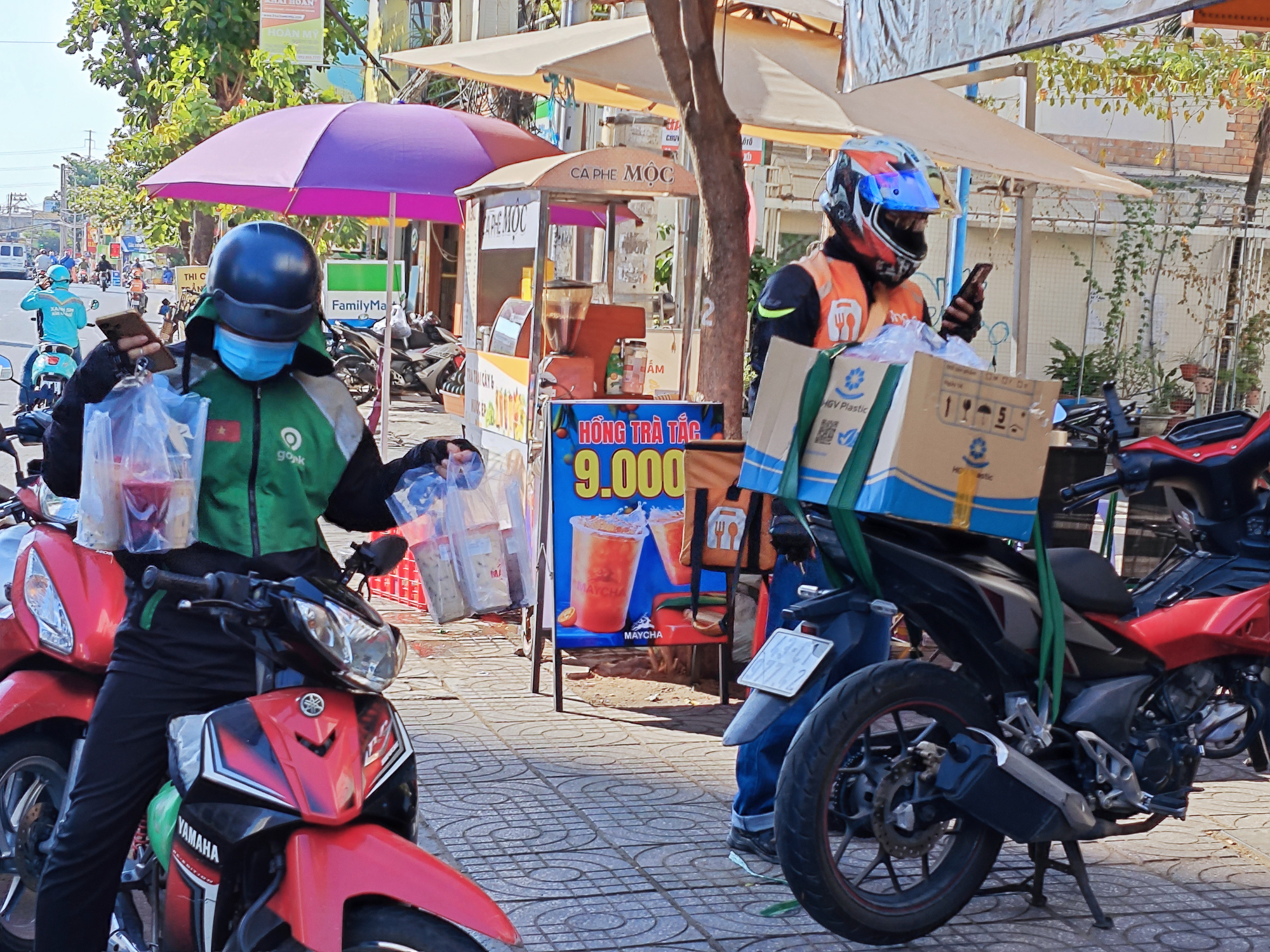 Tài xế giao đồ ăn, trùm kín mít để tránh sốc nhiệt do thời tiết nắng nóng trong những ngày đầu kỳ nghỉ lễ 30-4 - Ảnh: CÔNG TRUNG