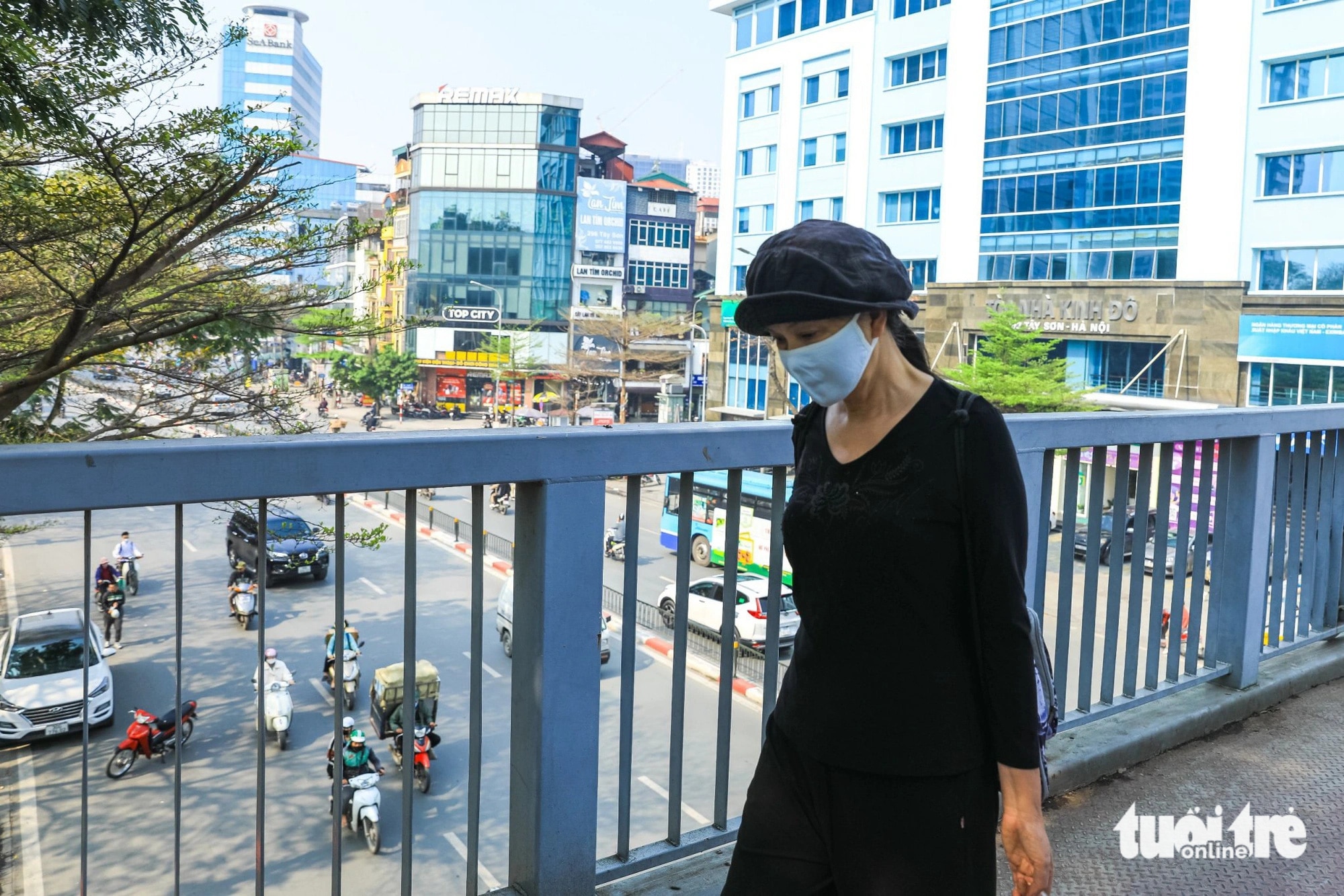 Dù đi bộ nhưng người dân Hà Nội vẫn đeo khẩu trang để tránh bụi - Ảnh: DANH KHANG