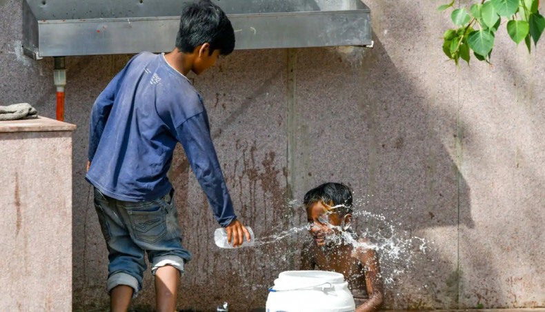 Trẻ em tắm nước giải nhiệt trong những ngày nắng nóng - Ảnh: NewAge