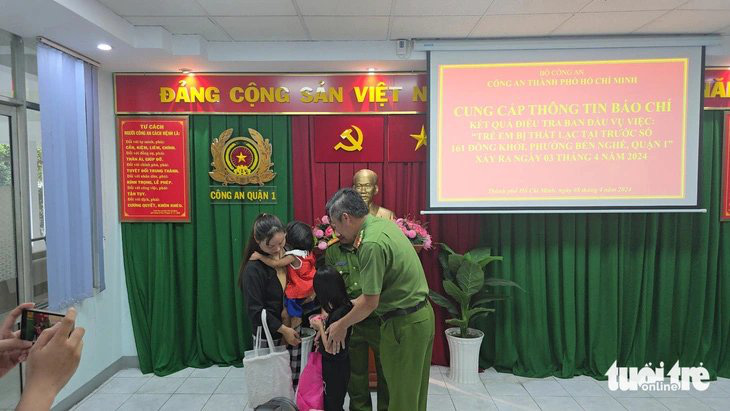 Người mẹ bán kẹo đoàn tụ hai con: 'Con an toàn là niềm vui lớn nhất'- Ảnh 1. Công an bàn giao hai cháu bé thất lạc cho chị Nguyễn Thị Chi - Ảnh: ĐAN THUẦN
