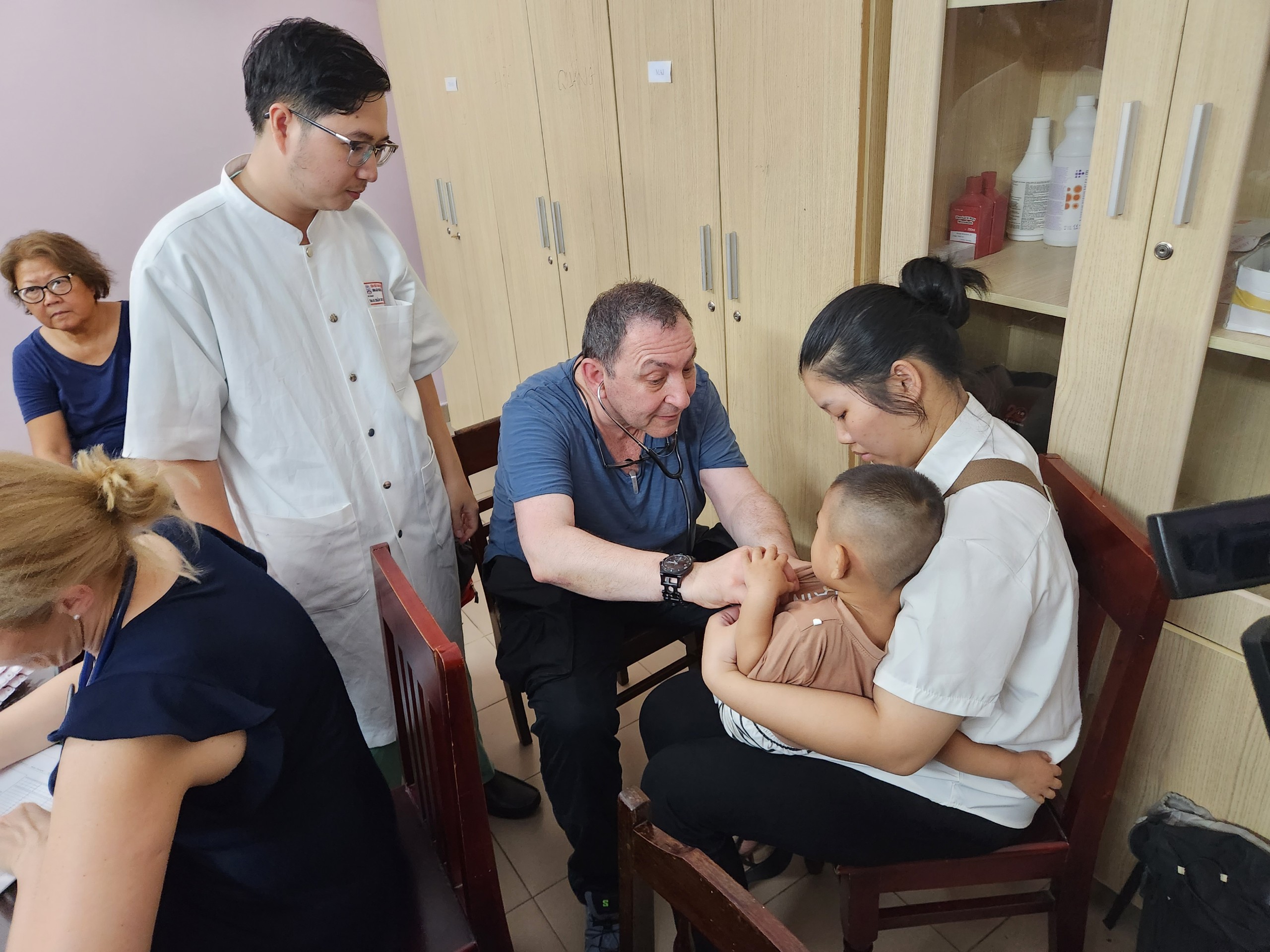 Nhiều em nhỏ dị tật hở môi, vòm miệng được phẫu thuật miễn phí- Ảnh 1. Bác sĩ nước ngoài khám sàn lọc cho các trẻ em mắc dị tật khe hở môi
