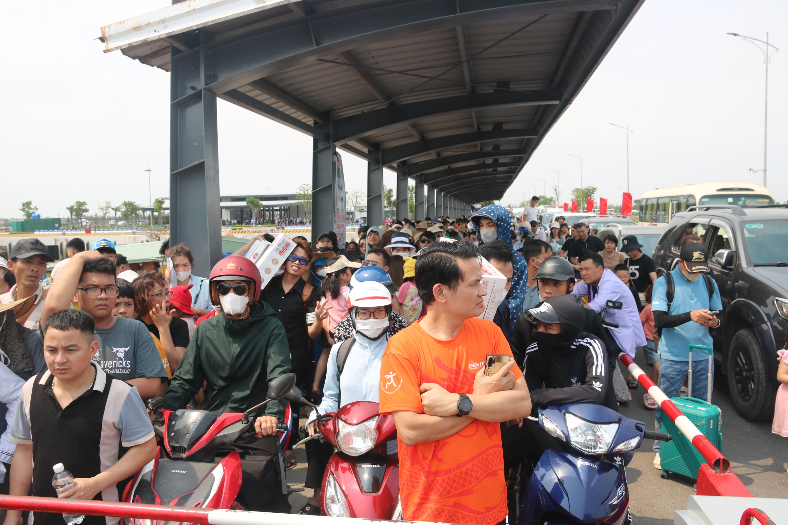 Phà ra đảo Cát Bà ùn tắc nhiều giờ, ô tô nối đuôi nhau hàng dài- Ảnh 1. Du khách từ các tỉnh thành phố phía Bắc chen chân, phơi nắng tại đầu bến phà Đồng Bài chờ đến lượt xuống phà ra đảo Cát Bà du lịch ngày 28.4