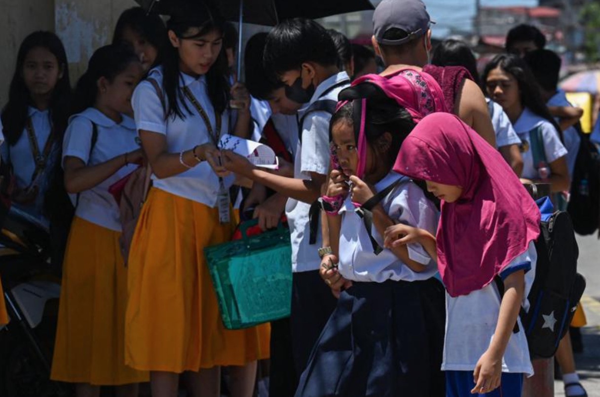 Học sinh Philippines đi bộ dưới trời nắng gay gắt tại thủ đô Manila tháng 4-2024, trước khi có thông báo đóng cửa trường học - Ảnh: AFP
