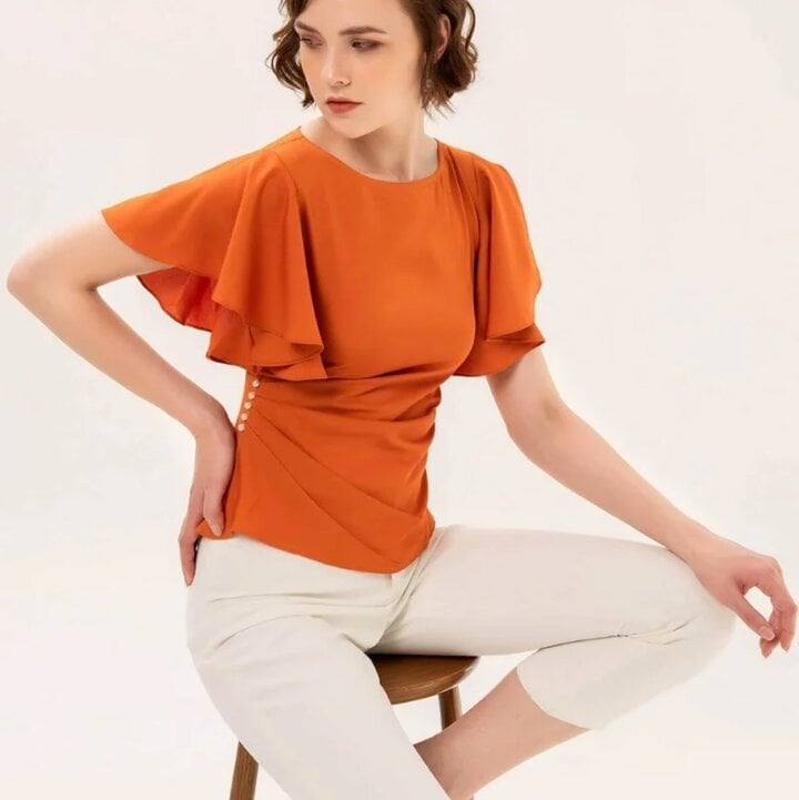 Khi kết hợp vào thời trang công sở, màu cam đào đem đến cảm giác trẻ trung, tươi mới. Những bộ cánh đi làm không còn cứng nhắc mà đêm đến nguồn năng lượng sáng tạo cho người mặc.