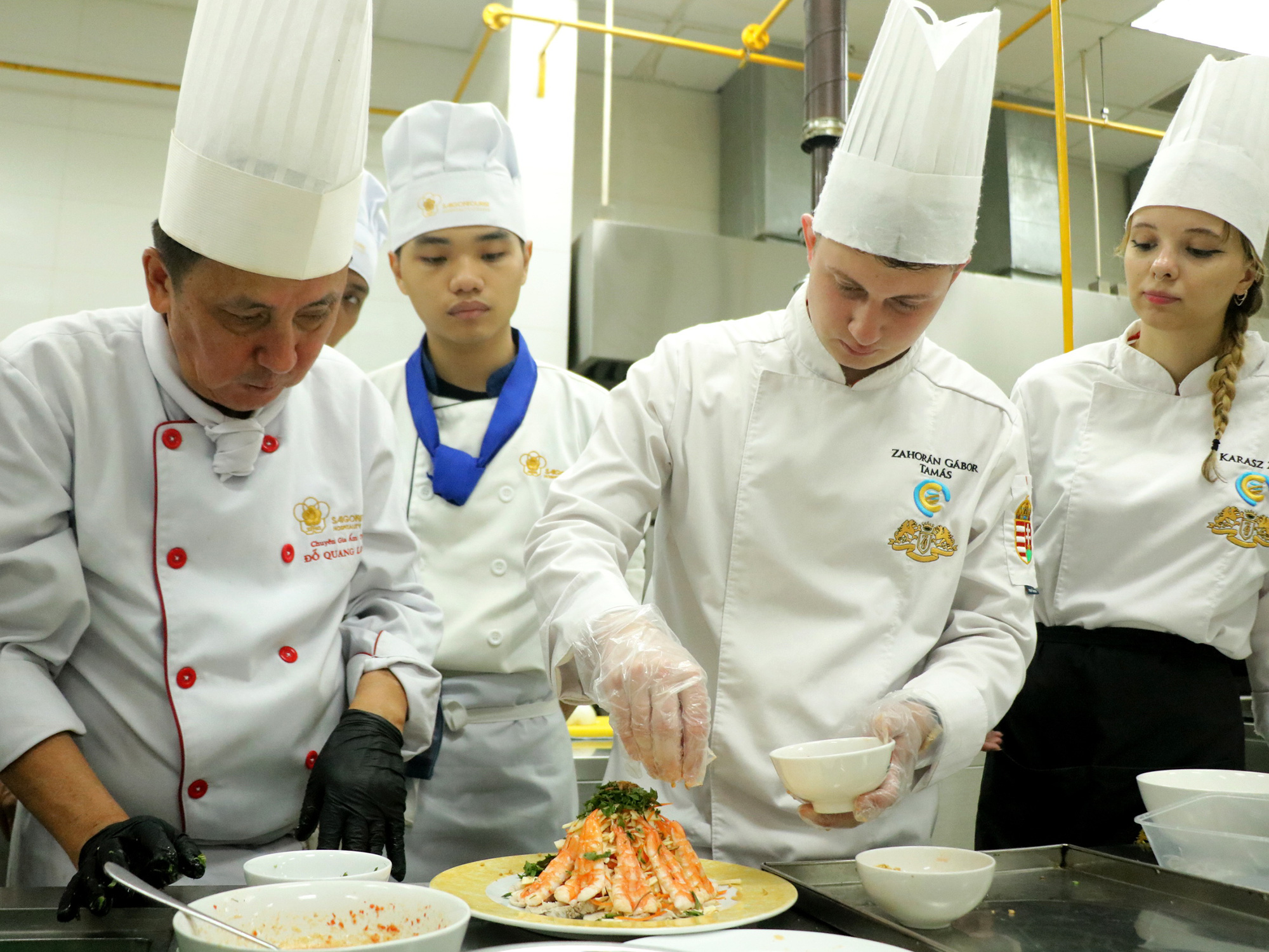 Sang Việt Nam học nghề bếp- Ảnh 1. Zahorán Gábor Tamás (thứ hai từ phải sang) đang làm món gỏi củ hũ dừa tôm thịt - Ảnh: TRỌNG NHÂN