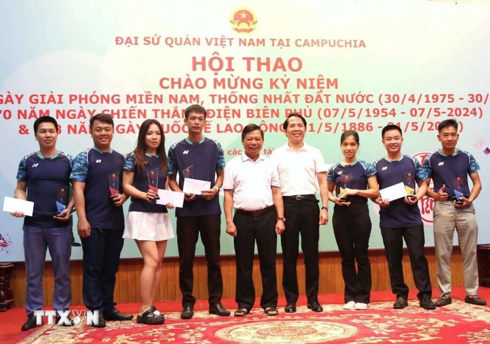 Đại sứ Việt Nam tại Campuchia Nguyễn Huy Tăng (giữa) trao giải Nhất, Nhì, Ba cho các vận động viên thi đấu môn cầu lông. (Ảnh: Hoàng Minh/TTXVN)