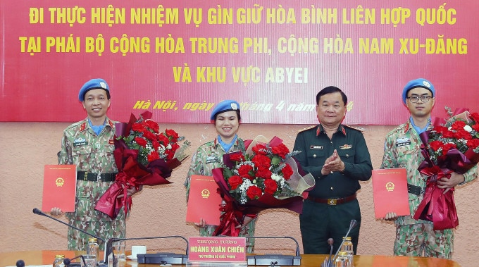 Thượng tướng Hoàng Xuân Chiến trao quyết định và tặng hoa cho ba sĩ quan nhận nhiệm vụ tham gia gìn giữ hòa bình Liên Hợp Quốc. Ảnh: Trọng Đức