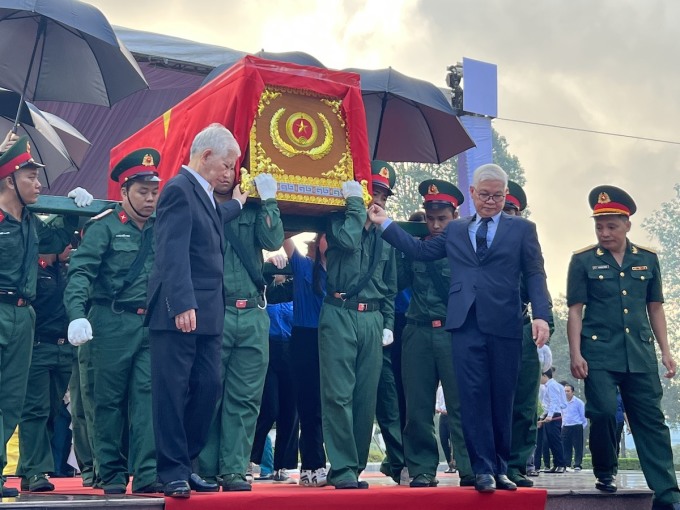 Nguyên chủ tịch nước Nguyễn Minh Triết thực hiện nghi thức di quan các liệt sĩ. Ảnh: Phước Tuấn