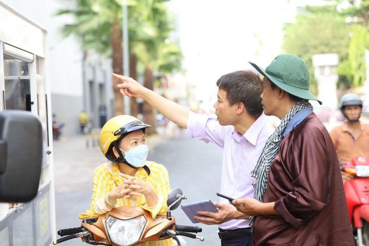 Xe điện du lịch trung tâm TP.HCM dần hút khách, giới trẻ hào hứng trải nghiệm- Ảnh 2. Người đi đường ở quận 1 (ngồi xe ) hỏi về lộ trình, giá cả… để thuê xe cho các con đi chơi - Ảnh: NGỌC QUÝ