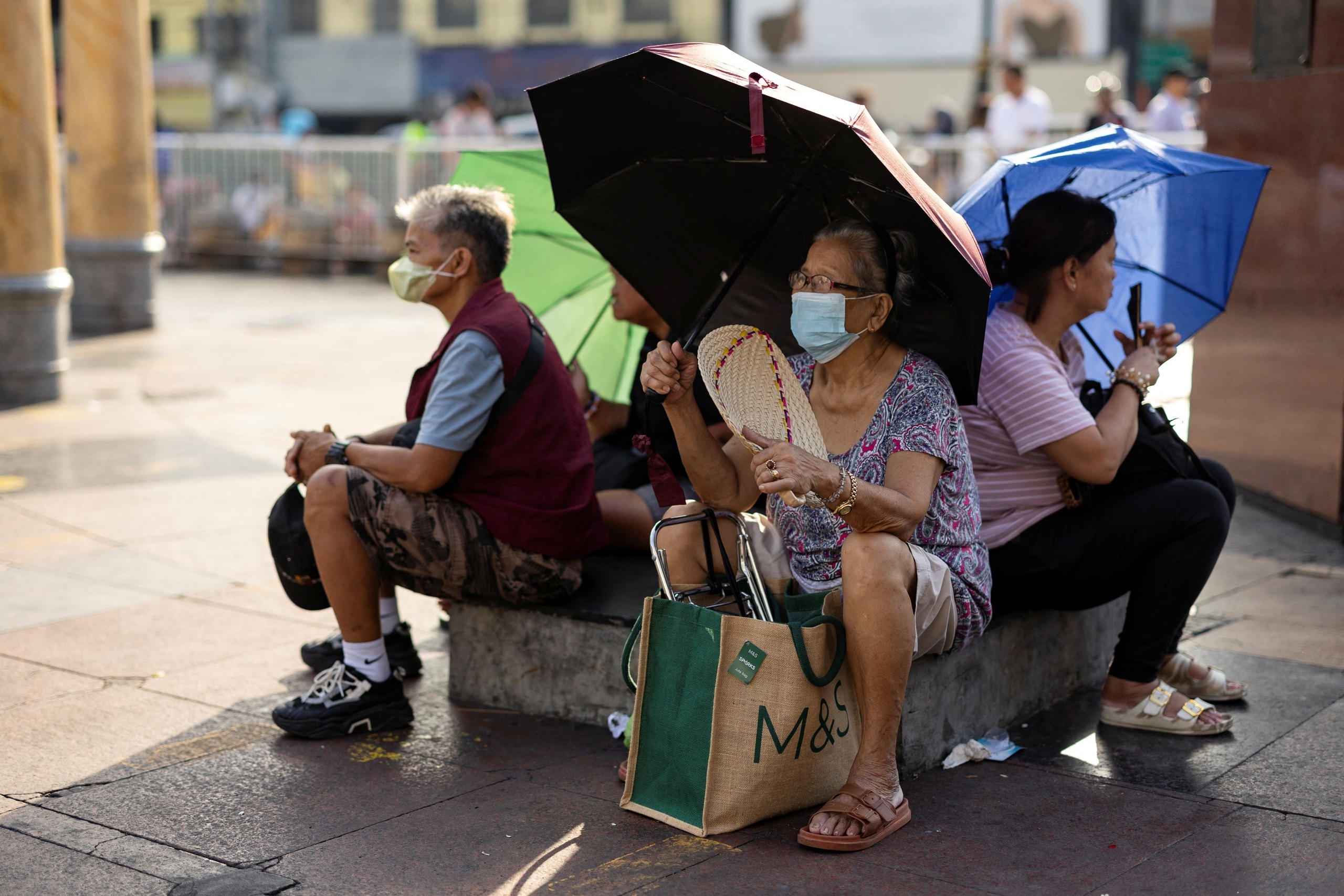 Nhiều người dân cầm ô bên ngoài nhà thờ Quiapo trong một ngày nắng nóng ở Manila (Philippines) ngày 26.4.2024.