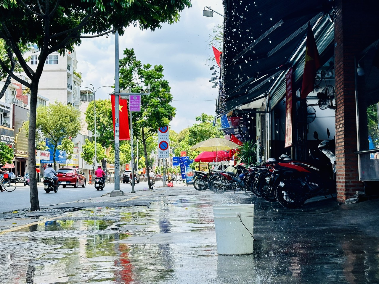 Không tin nổi, nắng nóng có lúc đã lên tới 51 độ C, người TP.HCM giải nhiệt thế nào?- Ảnh 7. Xịt nước làm mát vỉa hè cũng là cách mà nhiều chủ nhà lựa chọn. Người còn vào chỗ râm tránh nắng còn vỉa hè 'phơi' cả ngày, chịu sao nổi