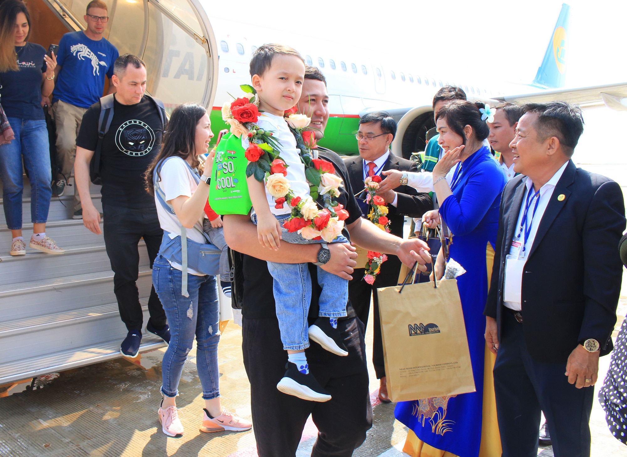 Các du khách Uzbekistan nhận những vòng hoa, phần quà chào đón từ ngành du lịch địa phương - Ảnh: MINH CHIẾN