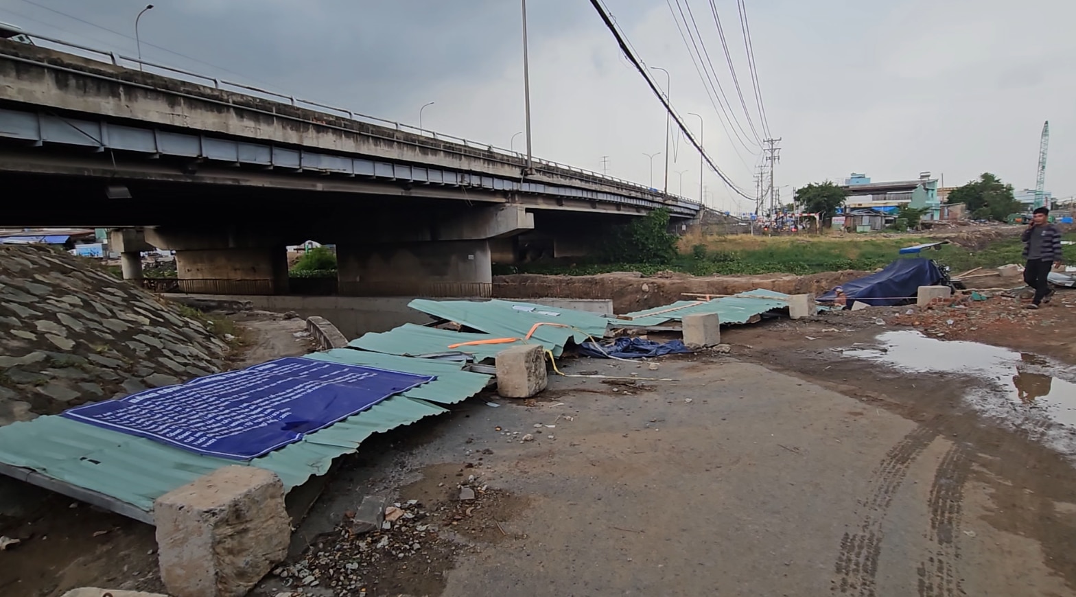 Hàng rào tôn công trình thi công bờ kè tại chân cầu Bình Thuận bị gió quật ngã