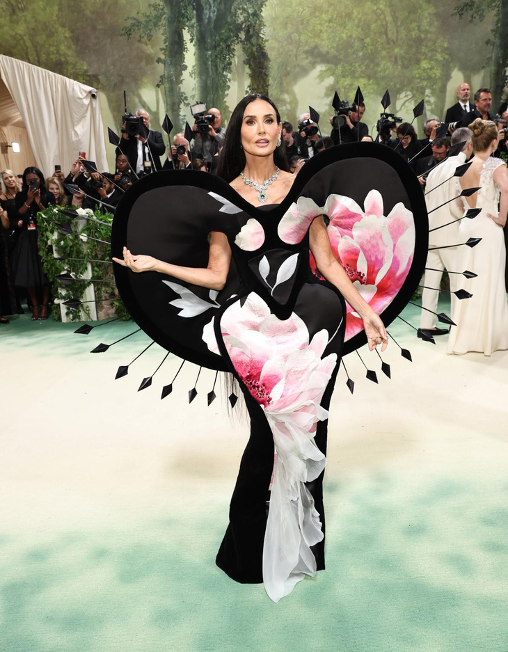 Thiết kế độc lạ của Demi Moore gây chú ý trên thảm đỏ Met Gala, chiếc váy được làm bằng giấy dán tường cổ điển, nổi bật với những bông hoa màu hồng và trắng ở mặt trước và những mũi tên xếp nếp phần cánh. Page Six nhận xét Demi Moore đã hoàn toàn chinh phục chủ đề năm nay - Ảnh: Getty Thiết kế độc lạ của Demi Moore gây chú ý trên thảm đỏ Met Gala, chiếc váy được làm bằng giấy dán tường cổ điển, nổi bật với những bông hoa màu hồng và trắng ở mặt trước và những mũi tên xếp nếp phần cánh. Page Six nhận xét Demi Moore đã hoàn toàn chinh phục chủ đề năm nay - Ảnh: Getty