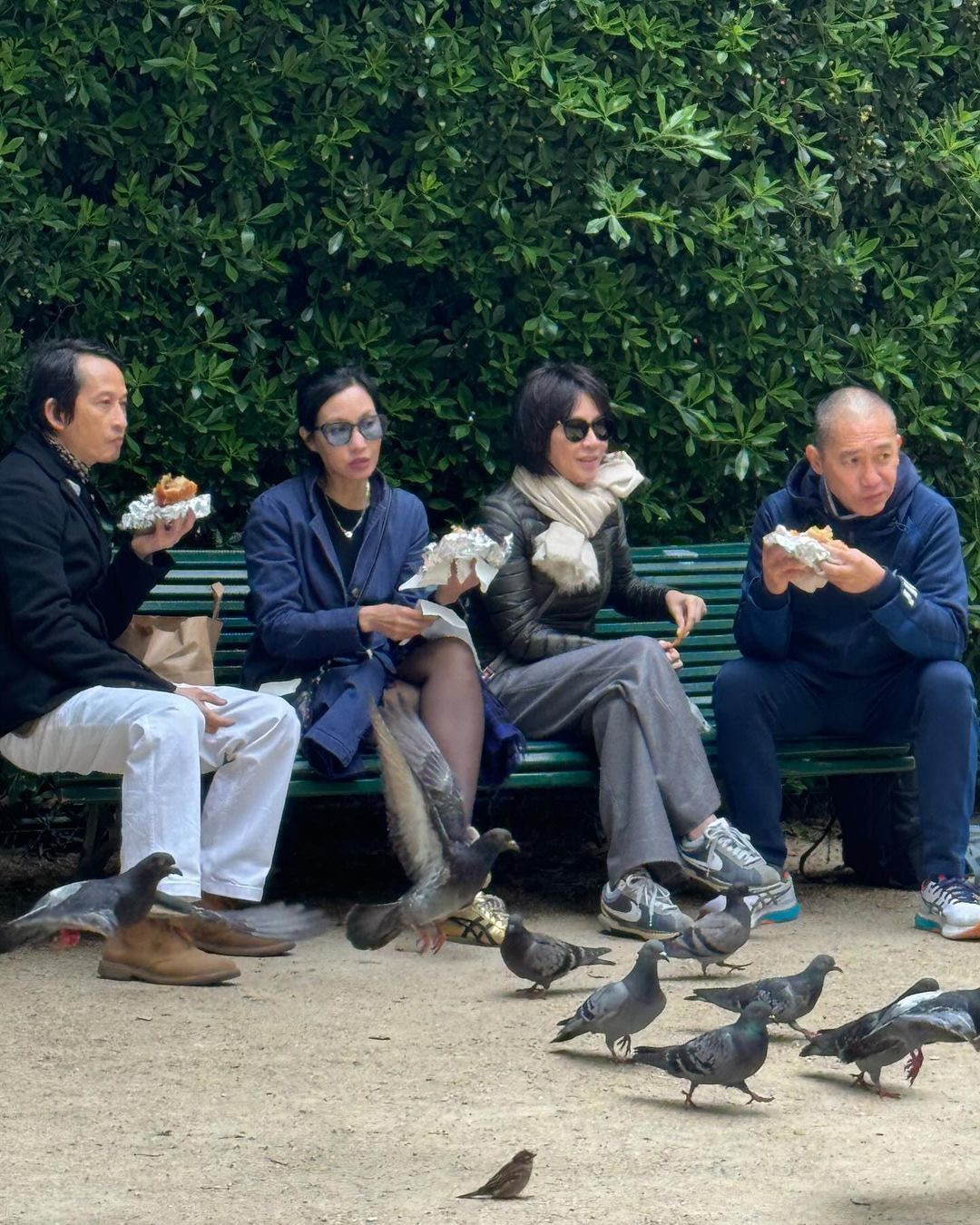 Vợ chồng Trần Anh Hùng và Lương Triều Vỹ cùng ngồi trong khuôn viên bảo tàng ăn bánh mì, ngắm bồ câu - Ảnh: Instagram Lưu Gia Linh